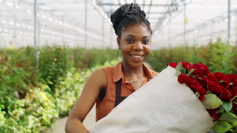 Feliz-Mujer-Afroamericana-Con-Rosas-En-Invernadero-De-Flores